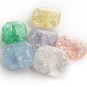 May include: Six colorful glass beads with a textured, frosted finish. The beads are in shades of green, yellow, purple, pink, and blue.