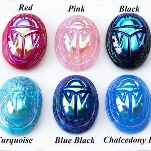 May include: Six iridescent glass scarab beetle charms in various colors: red, pink, black, turquoise, blue black, and chalcedony blue.