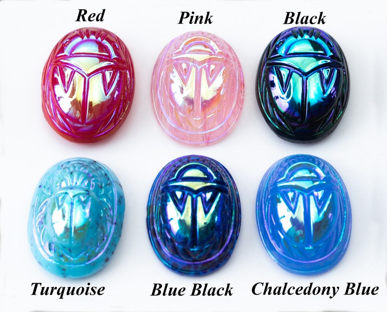 May include: Six iridescent glass scarab beetle charms in various colors: red, pink, black, turquoise, blue black, and chalcedony blue.