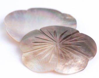 May include: Two iridescent mother of pearl shell dishes, one with a carved sunburst design.