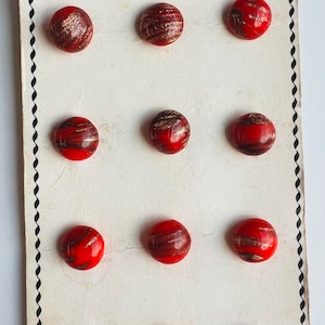 Puede incluir: Tarjeta vintage de botones de moda rojos y dorados. Los botones redondos tienen un acabado brillante y un diseño en espiral. La tarjeta dice "Glamour Fashion Buttons" y "Made in Czechoslovakia". Cada botón mide 11 mm de diámetro.