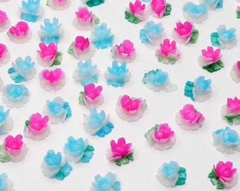 May include: Assortment of small, colorful, plastic flowers. The flowers are in shades of pink, blue, and white. They are perfect for adding a touch of whimsy to crafts, nail art, or other projects.