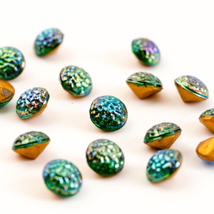 Pode incluir: Conjunto de botões redondos de vidro verde e dourado iridescentes. Os botões têm uma superfície texturizada e um centro elevado.