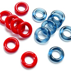 May include: A collection of red and blue glass rings. The red rings are opaque and the blue rings are translucent.
