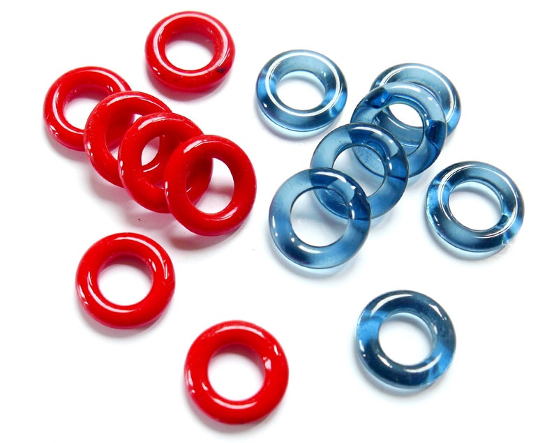May include: A collection of red and blue glass rings. The red rings are opaque and the blue rings are translucent.