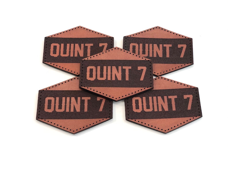 May include: Five brown leather patches with a stitched border and the text "QUINT 7" in white lettering.