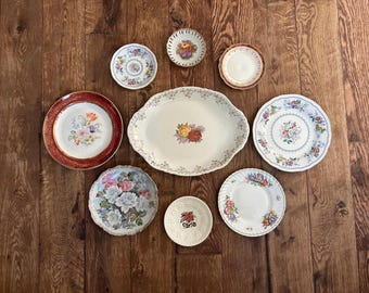 May include: A collection of vintage floral patterned plates and serving dishes. The assortment includes a large oval platter, several small plates, and a few medium-sized plates, all with colorful floral designs.