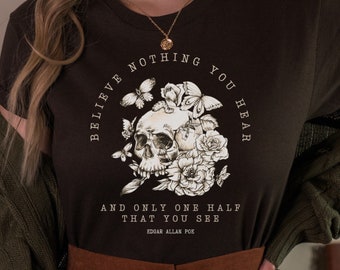 May include: A black t-shirt with a skull and flowers graphic and the text "Believe nothing you hear and only one half that you see - Edgar Allan Poe".