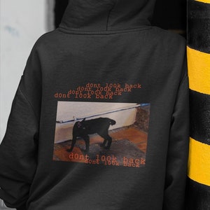 May include: Black hoodie with a graphic print of a black cat and the text "dont look back" repeated multiple times.