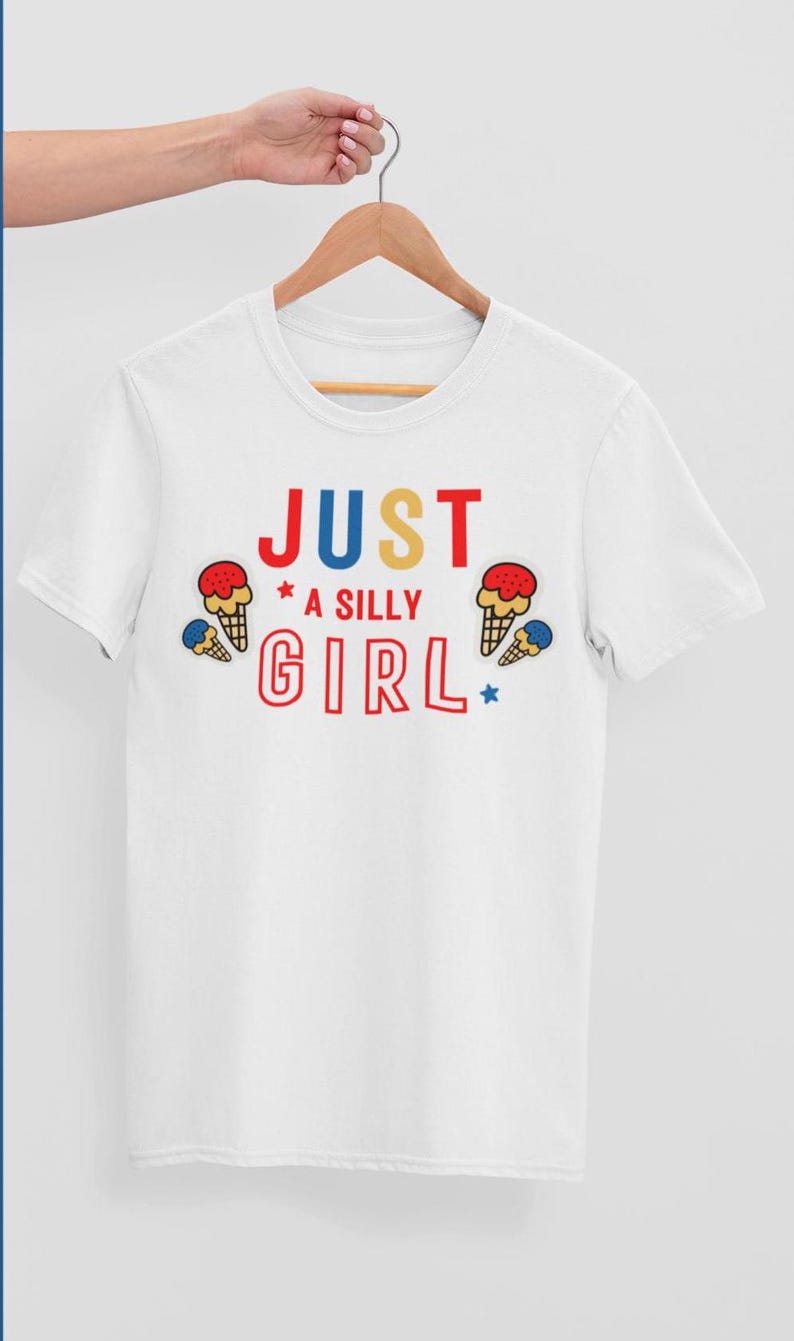 May include: White t-shirt with the text "JUST A SILLY GIRL" in colorful letters and ice cream cone graphics.