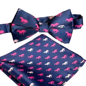 May include: A navy blue bow tie and pocket square set. The bow tie is pre-tied and features a pink horse pattern. The pocket square has a similar design. The set is made of a silky material and is suitable for formal occasions.