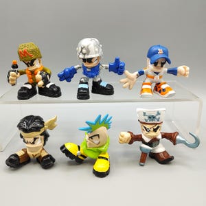 May include: A set of six small plastic action figures featuring diverse characters including a soldier with a green helmet, a futuristic figure in silver armor, a baseball player, a warrior with black hair, a punk character, and a pirate with a hook.