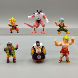 May include: A collection of six colorful Dragon Ball Z action figures. The figures include characters in various poses, with detailed costumes and vibrant colors. The figures are set against a neutral background.