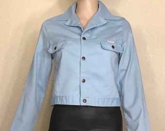 May include: A light blue denim jacket with a button closure and a small "Diesel" logo patch on the chest.