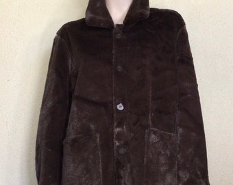 May include: A brown faux fur jacket with a button closure and two large pockets. The jacket has a collar and long sleeves.
