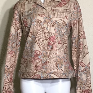 May include: A beige jacket with a floral and geometric pattern. The jacket has a button-up front and long sleeves.