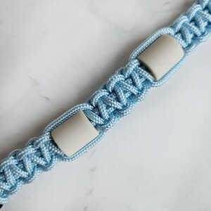 Op de afbeelding: Blauw paracord anti-teken bandje. Kleur optie : Oase