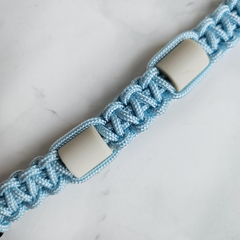 Op de afbeelding: Blauw paracord anti-teken bandje. Kleur optie : Oase