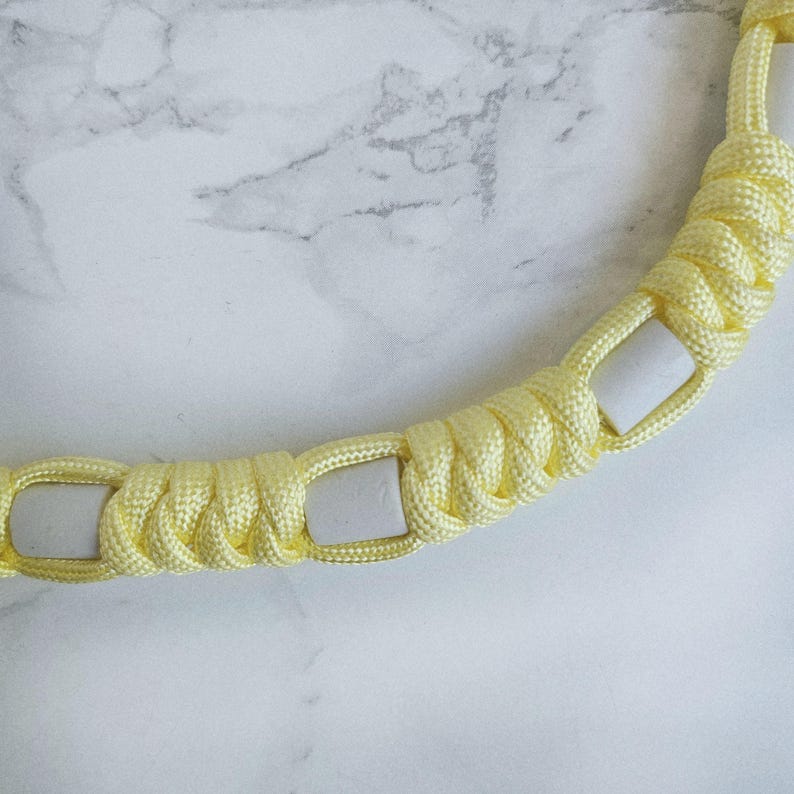 Op de afbeelding: Geel paracord anti-teken bandje. Kleur optie : Lightning