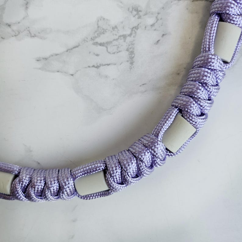 Op de afbeelding: Paars paracord anti-teken bandje. Kleur optie : Emoryi