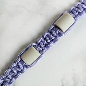 Op de afbeelding: Paars paracord anti-teken bandje. Kleur optie : Emoryi