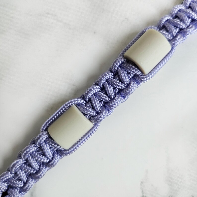 Op de afbeelding: Paars paracord anti-teken bandje. Kleur optie : Emoryi