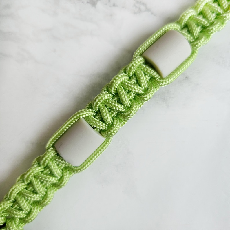 Op de afbeelding: Groen paracord anti-teken bandje. Kleur optie : Ufo