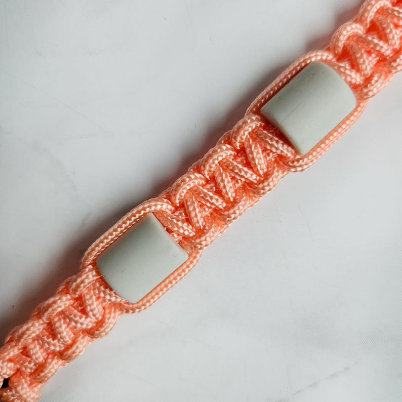 Op de afbeelding: Oranje paracord anti-teken bandje. Kleur optie : Lava