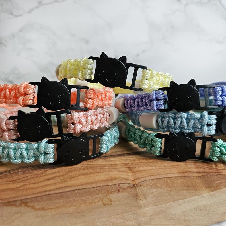 Op de afbeelding: handgemaakte anti-teken bandjes in verschillende pastel kleuren. Gemaakt van Paracord met EM keramische kralen. Natuurlijke optie tegen tegen & vlooien.