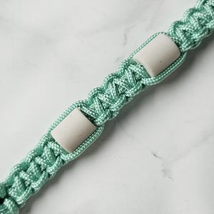 Op de afbeelding: Groen blauw paracord anti-teken bandje. Kleur optie : Sea glass
