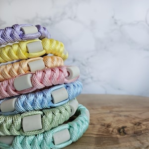 Op de afbeelding: verstelbaar paracord anti-teken bandjes in pastelkleur