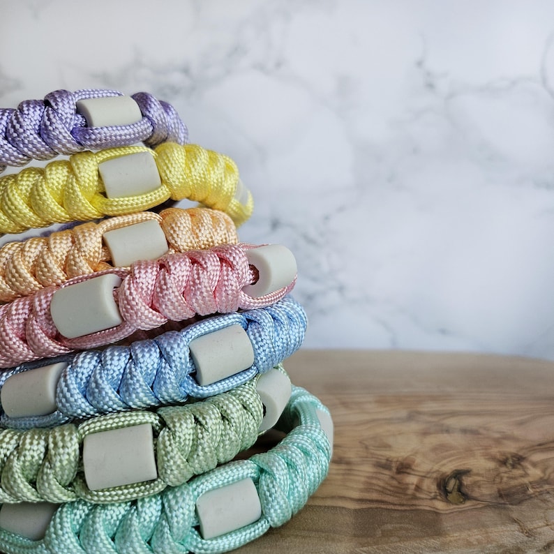 Op de afbeelding: verstelbaar paracord anti-teken bandjes in pastelkleur
