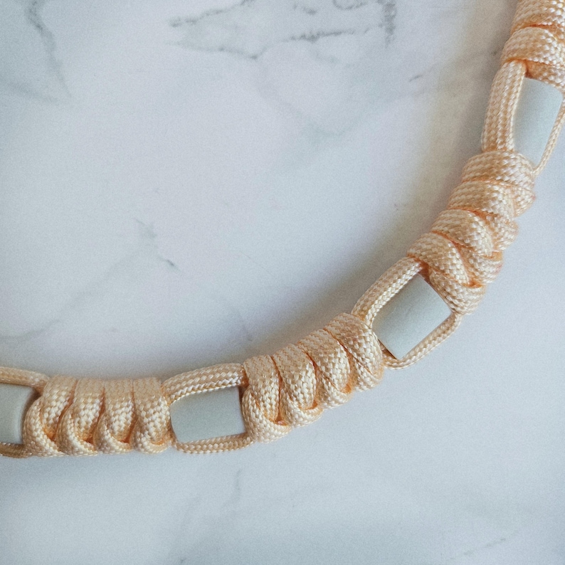 Op de afbeelding: Oranje paracord anti-teken bandje. Kleur optie : Lava