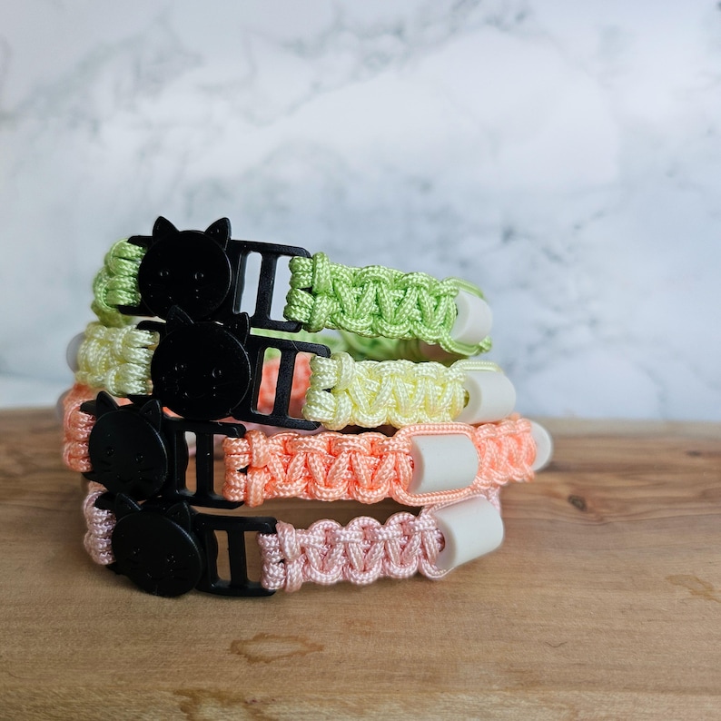 Op de afbeelding: Paracord anti-teken bandjes in pastel kleur voor katten