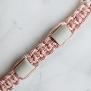 Op de afbeelding: Roze paracord anti-teken bandje. Kleur optie : Fata morgana
