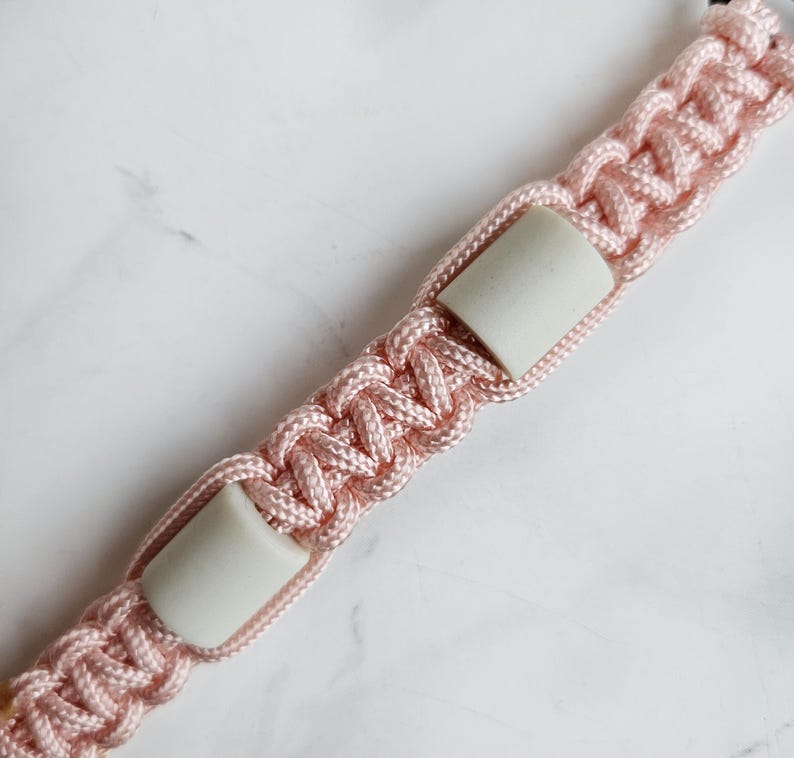 Op de afbeelding: Roze paracord anti-teken bandje. Kleur optie : Fata morgana
