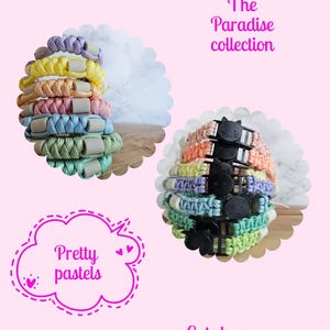 May include: A collection of braided paracord bracelets in pastel colors including lavender, yellow, peach, pink, blue, and green. Each bracelet features a small grey bead or a black cat-shaped buckle. Text reads: The Paradise collection, Pretty pastels, Cats have an additional color.