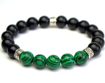 May include: A black onyx and malachite beaded bracelet with silver accents. The bracelet has a total of 19 beads, with 14 black onyx beads and 5 malachite beads.