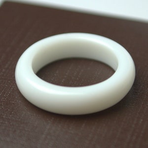 Puede incluir: Un anillo de cerámica blanca con un acabado liso y brillante.