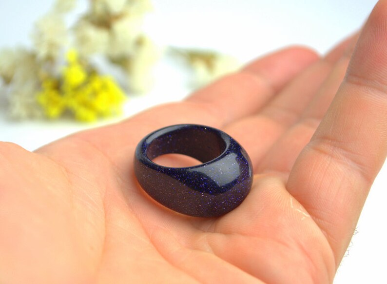 May include: A dark blue ring made of blue sandstone with a speckled texture.