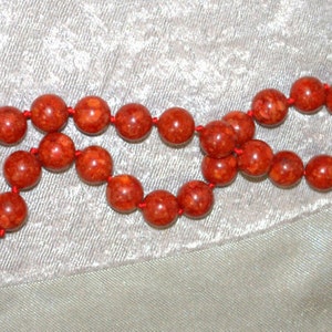 Peut inclure: Un collier de perles de corail rouge avec une fermeture &agrave; fermoir. Les perles sont rondes et ont une surface naturelle et textur&eacute;e.