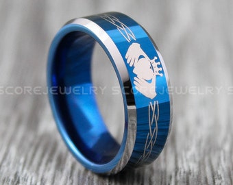 May include: A blue tungsten carbide ring with a silver Celtic knot design and a silver claddagh engraved on the band.
