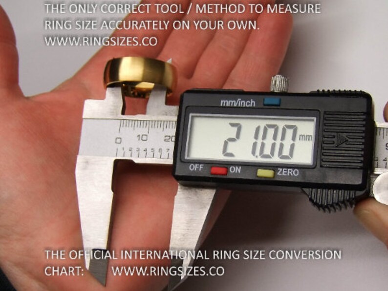 May include: A digital caliper measuring a gold ring. The caliper reads 21.00 mm. The text on the image reads "THE ONLY CORRECT TOOL / METHOD TO MEASURE RING SIZE ACCURATELY ON YOUR OWN. WWW.RINGSIZES.CO" and "THE OFFICIAL INTERNATIONAL RING SIZE CONVERSION CHART: WWW.RINGSIZES.CO"