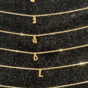 Puede incluir: Seis collares de oro con diferentes dijes de iniciales. Los dijes son las letras M, J, G, D, L y P.