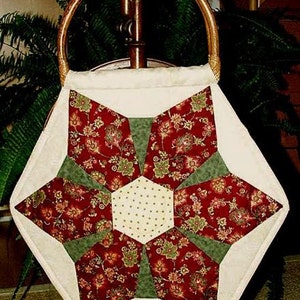 Peut inclure: Un sac en tissu blanc avec un motif de patchwork en forme d'étoile. Le sac a une poignée en bois brun et est fait de tissu rouge, vert et blanc.