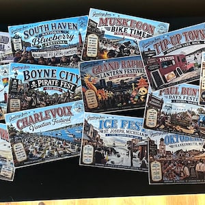 May include: A collection of vintage-style postcards featuring various festivals. The postcards showcase events like the Tulip Time Festival, Mackinac Island Lilac Festival, and Boyne City Pirate Fest, with colorful illustrations and text.