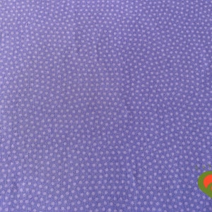 May include: A close-up of a lavender fabric with a repeating pattern of small, white polka dots. The fabric has a slightly textured appearance, and the dots are evenly spaced across the surface. The overall effect is a simple, yet classic design.