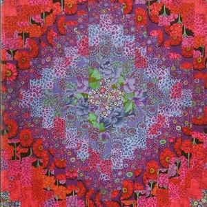 May include: A colorful quilt with a geometric pattern of squares and rectangles. The quilt is made up of various shades of pink, red, purple, and blue. The center of the quilt features a floral design.
