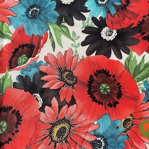 May include: A white fabric with a floral pattern featuring red poppies, black and white daisies, and blue flowers. The fabric has a vintage feel and would be perfect for crafting projects.