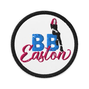 Könnte beinhalten: Gestickter Aufnäher mit weißem Hintergrund, schwarzem Rand und dem Text "BB Easton" in Blau und Pink. Auf der rechten Seite des Aufnähers befindet sich eine schwarz-weiße Silhouette einer Person.